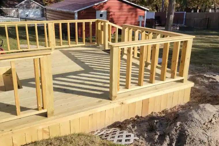 Fresh pine posts, rails and pickets mid-build with sand fill around the footings